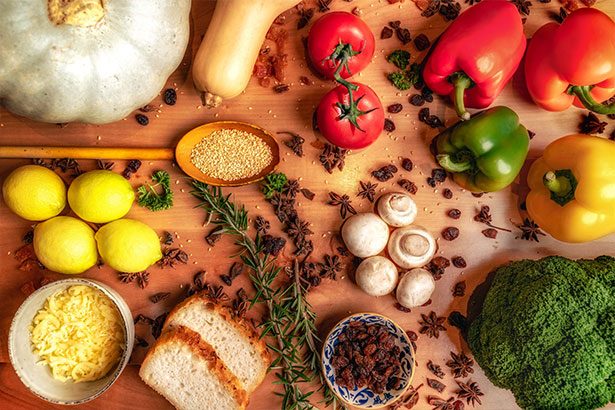 a chopping board artfully displaying herbs, spices, and vegetables